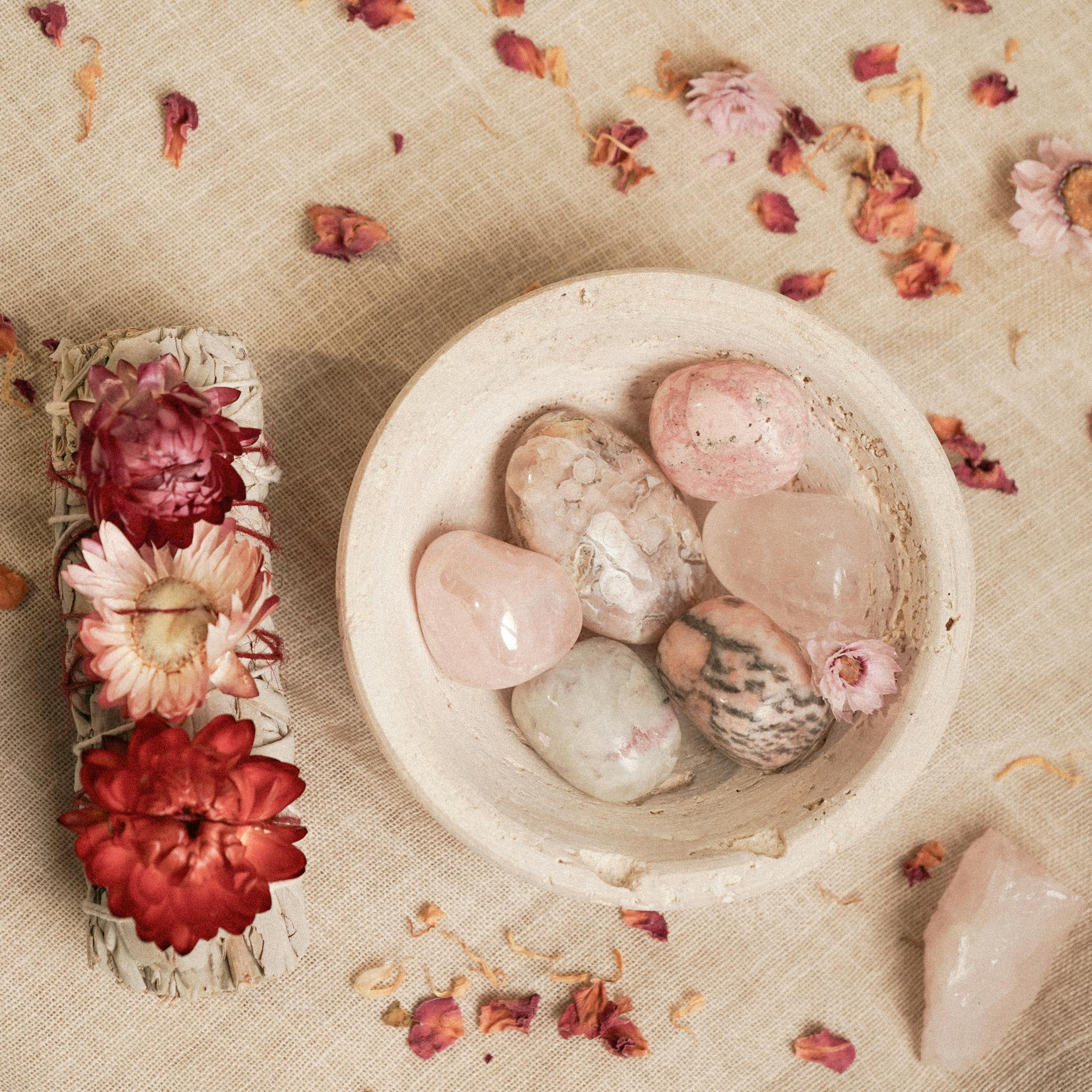 Aesthetic arrangement of healing crystals and dried flowers on linen for meditation and decor.
